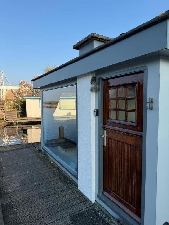 a house with a glass door and a window at Floating Hideaway in Leimuiden