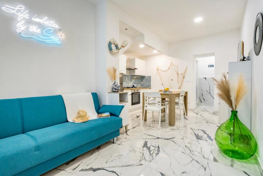 a living room with a blue couch and a table at Kai Loft & Suite - By the Sea in Giardini Naxos