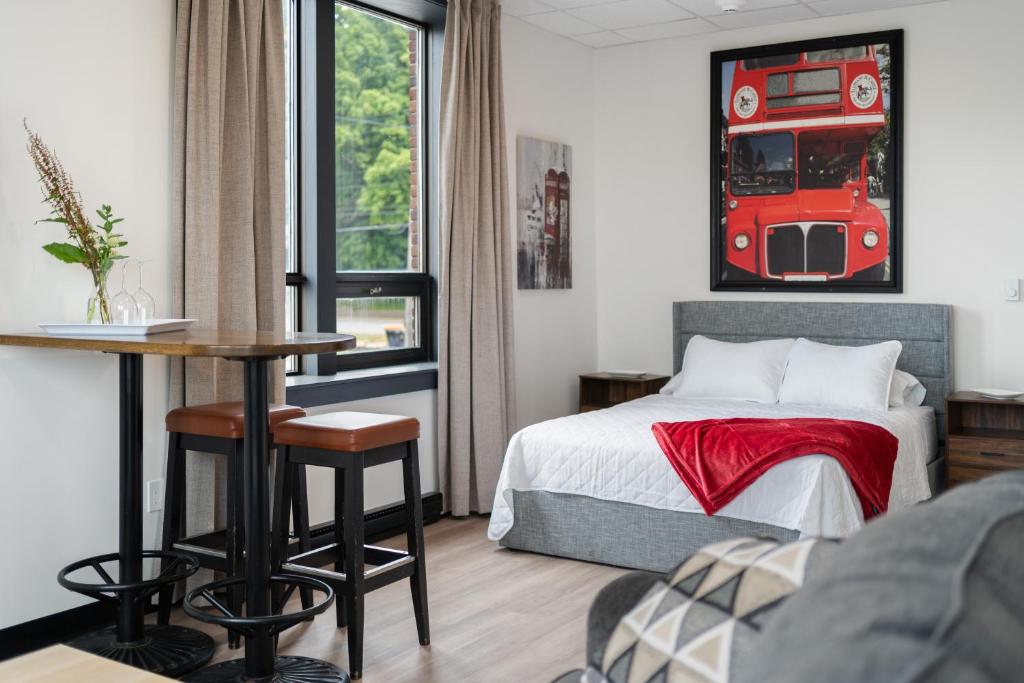 a bedroom with a bed with a red bus picture on the wall at Bridge View at The MillRows Suites in New Glasgow