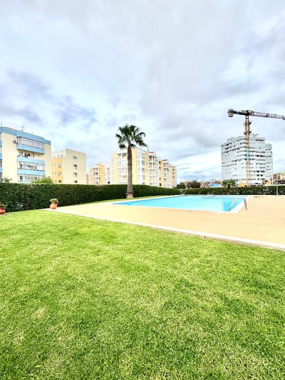 an empty swimming pool in a city with tall buildings at Renaissance Sunrise Inn Algarve in Portimão