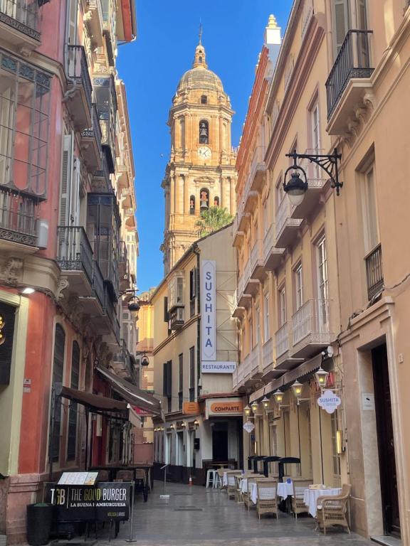 a city street with a clock tower in the background at Catedral Larios Centro in Málaga