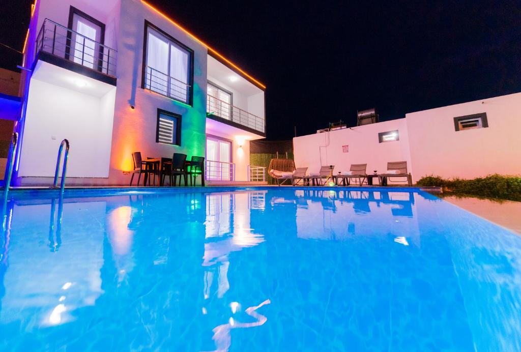 a swimming pool in front of a house at night at Villa adelina in Çavdır