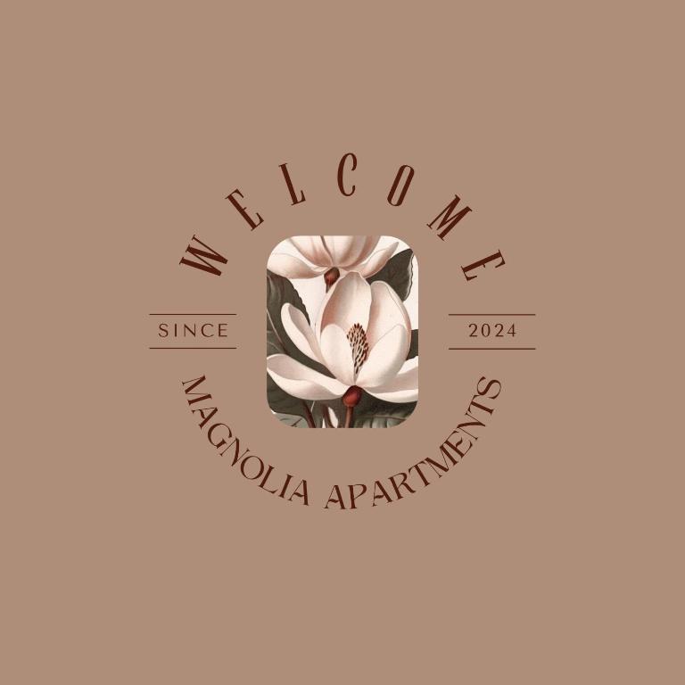 a logo for aarmaarmaarmaarma restaurant with a white flower at Magnolia Urban Apartments, Corfu Town in Ágios Rókkos