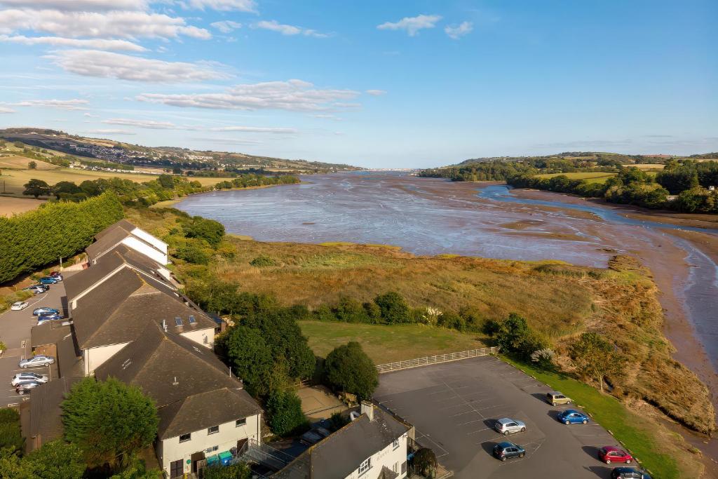 an aerial view of a river with cars in a parking lot at Sycamore in Newton Abbot