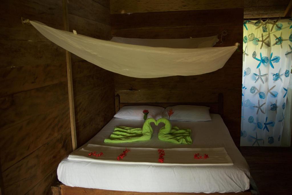 a bed in a wooden room with a canopy at Cabaña los Termales in Nuquí