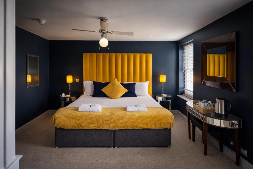 a bedroom with a large bed with blue walls at Crescent Victoria Hotel in Margate