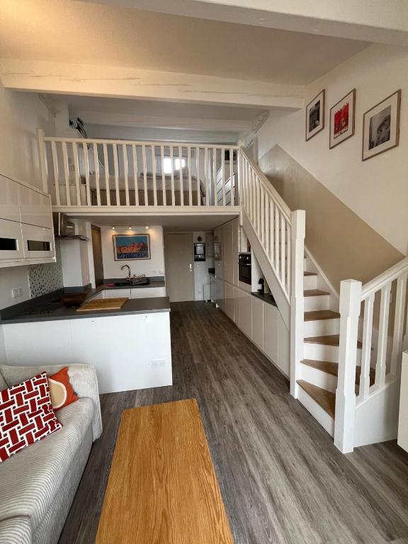 a living room with a staircase and a kitchen at Nid du port in Grimaud