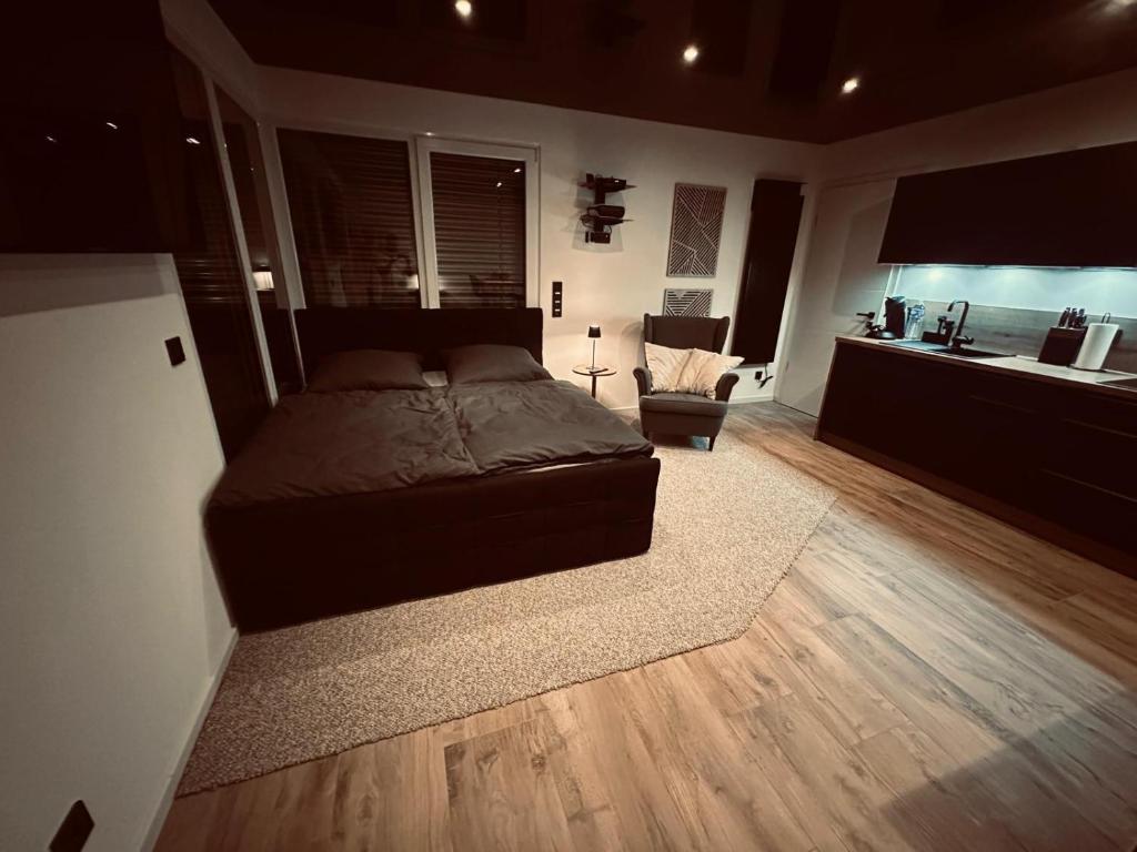 a bedroom with a large bed and a kitchen at Apartment Timeout in Welschbillig