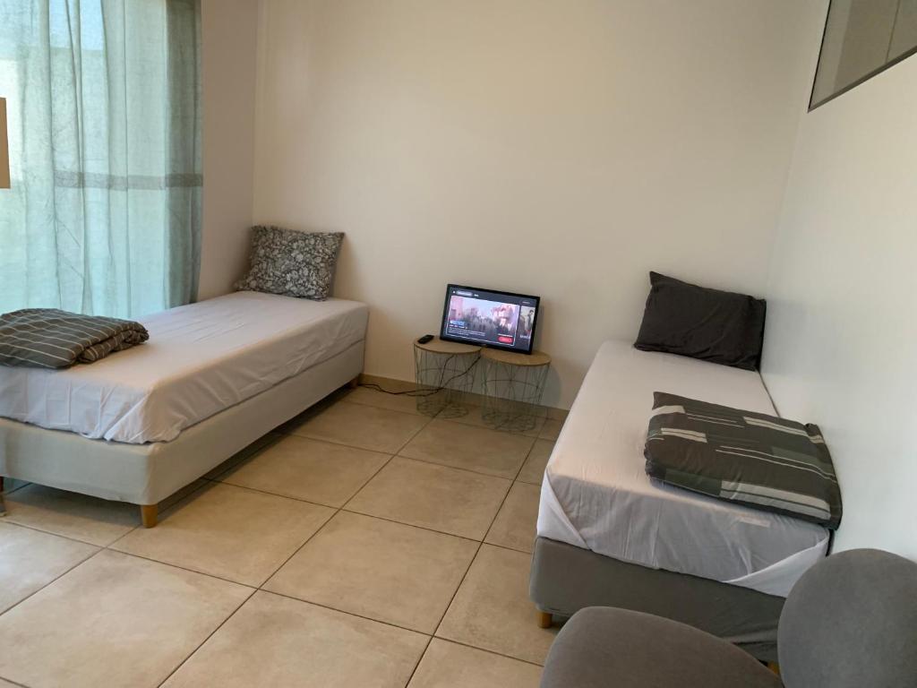 a bedroom with two beds and a tv in it at Chambre Lux in Luxembourg