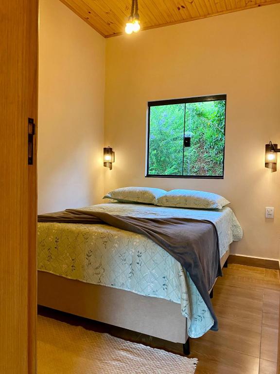 a bedroom with a bed and a window at Casa Araucária in Cunha