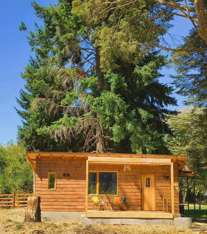 a small log cabin with a tree at Cabaña El Refugio in Lago Puelo