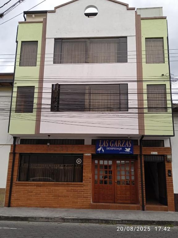 a building with a sign on the front of it at Hospedaje Las Garzas in Ibarra