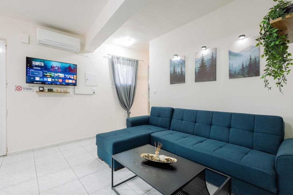 a living room with a blue couch and a table at The Calm City Escape in Heraklio