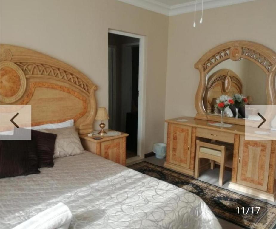 a bedroom with a bed and a desk with a mirror at Hollywood Heights Accommodation in Barrydale