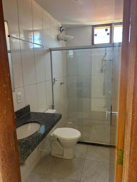 a bathroom with a toilet and a sink and a shower at Apt Pituba 500m Praia in Itacaré