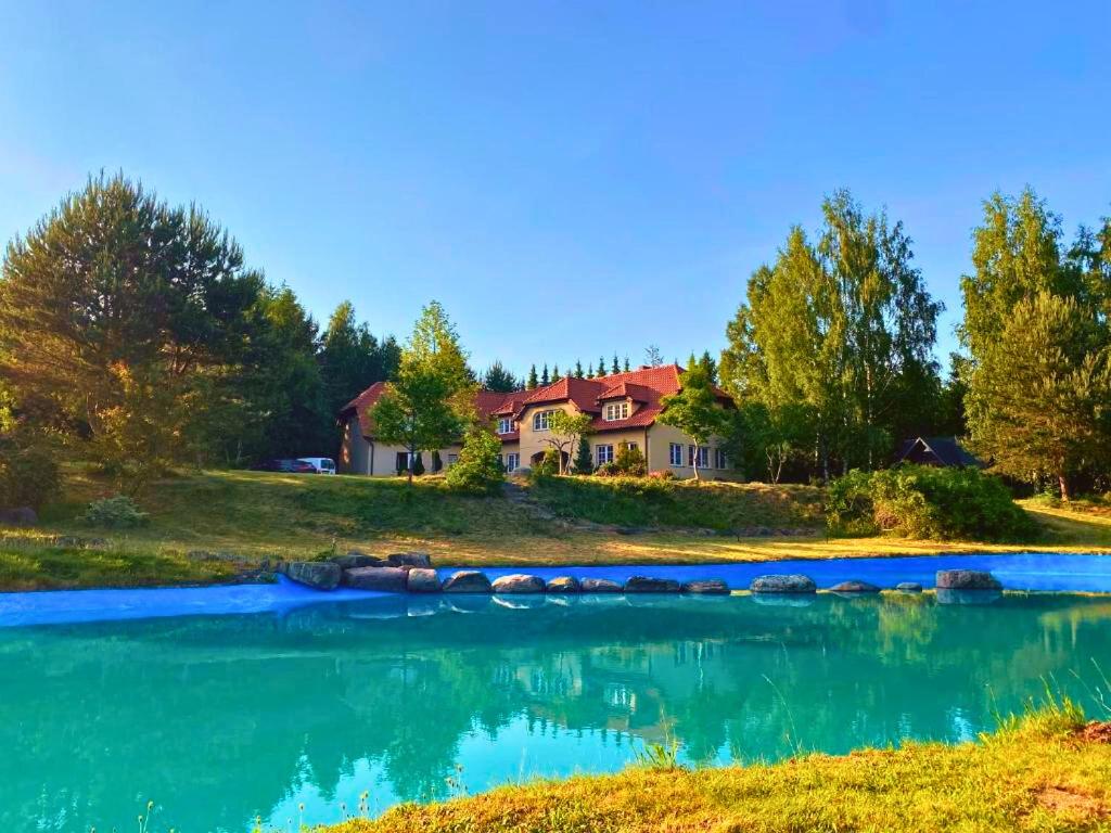 a house on a hill next to a river at Dworek Na Uboczu in Sulicice