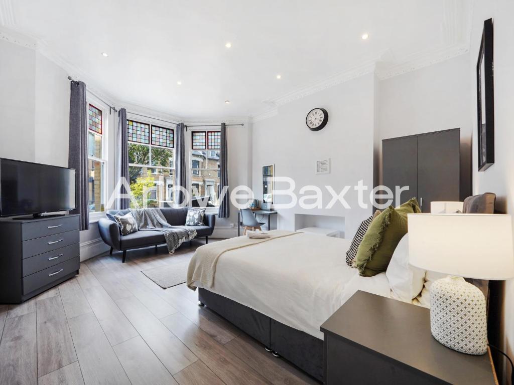 a bedroom with a large bed and a tv at Hackney Guest Rooms in London