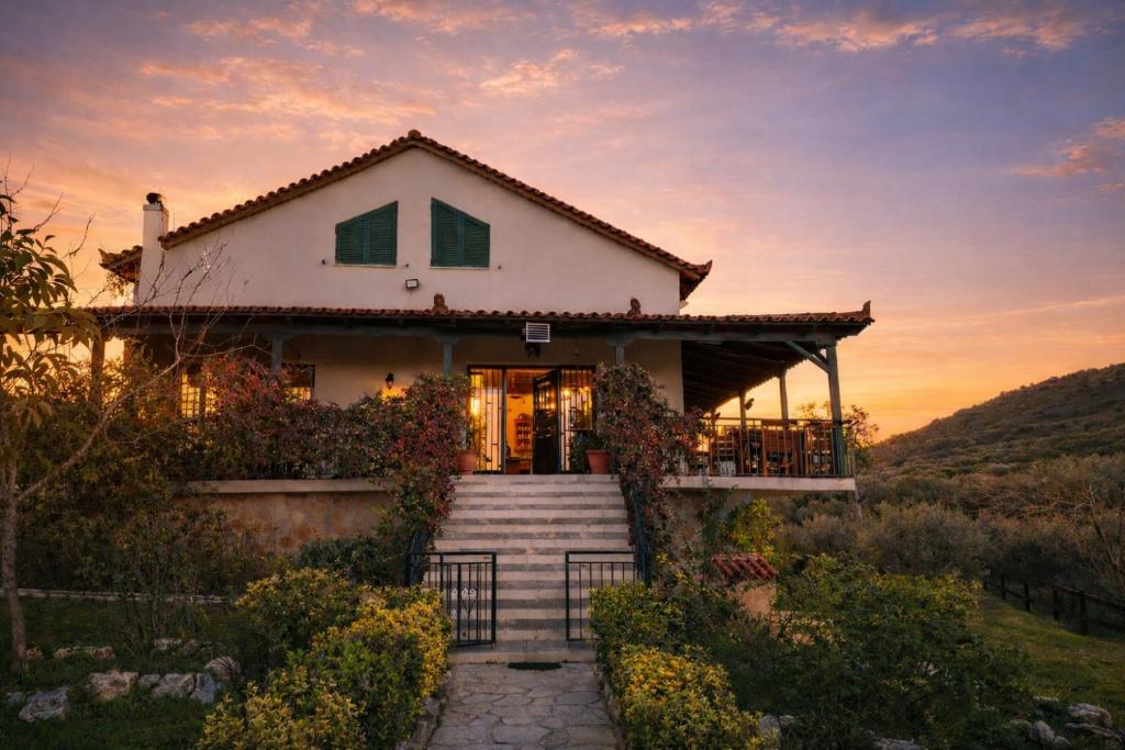 a house with a sunset in the background at Estate Tsiati in Piryiótika