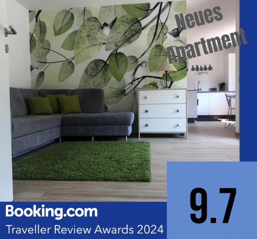 a living room with a couch and green leaves mural at Apartments "Am Ardetzenberg" in Feldkirch