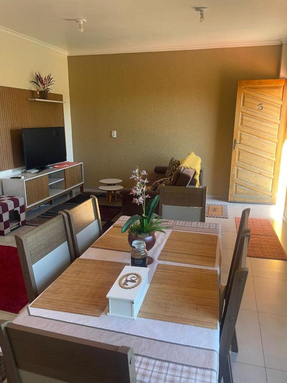 a living room with a dining table and a living room with a couch at Apartamento Aconchegante 2 Quartos in Tabapira