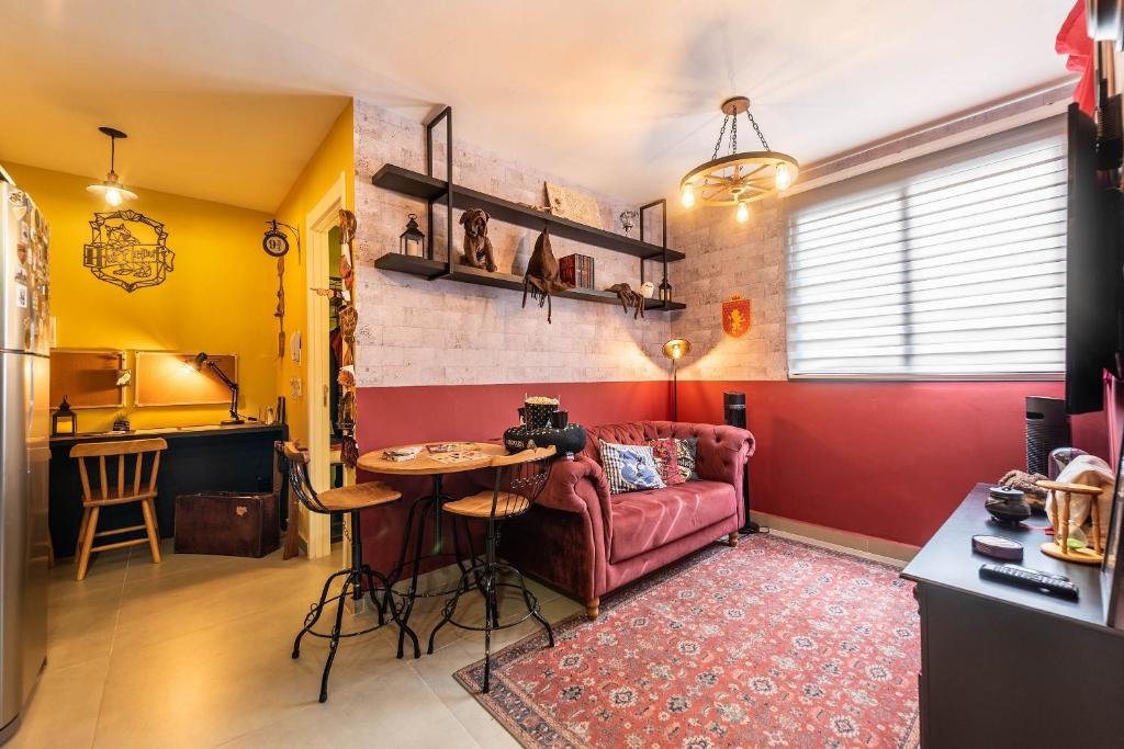 a living room with a red couch and a table at Immersive Hogwarts Experience – HP in São Paulo