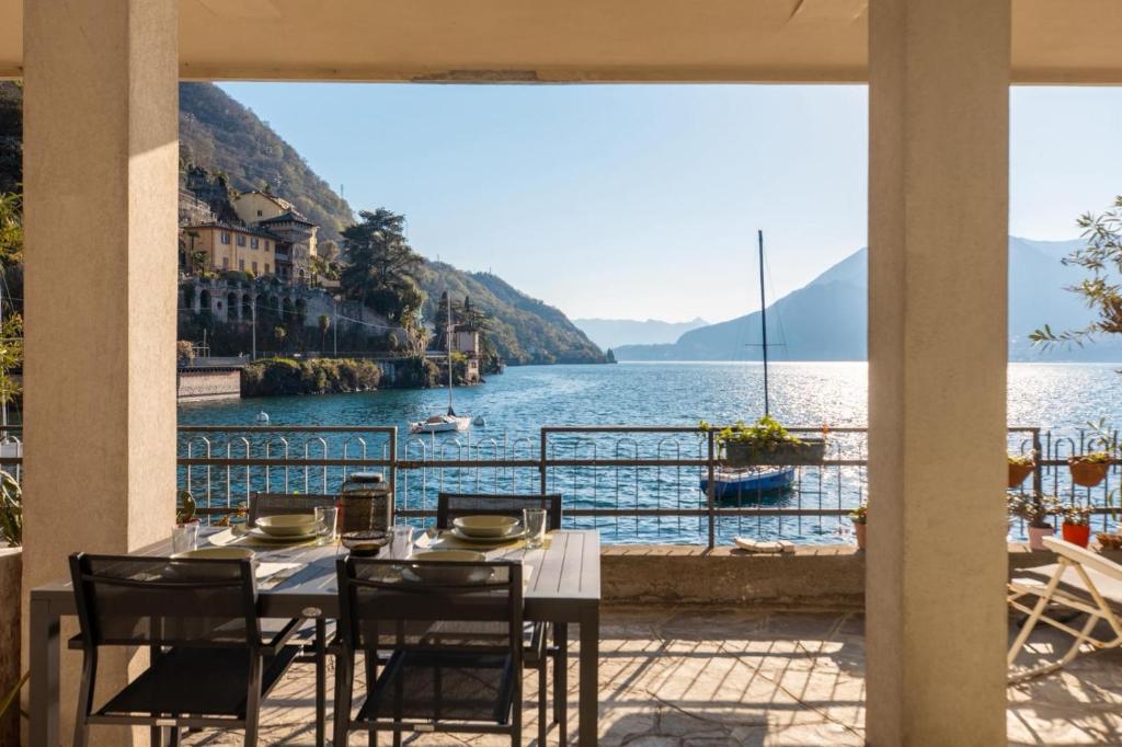 a table with chairs and a view of a lake at Gli Oleandri in Bellano