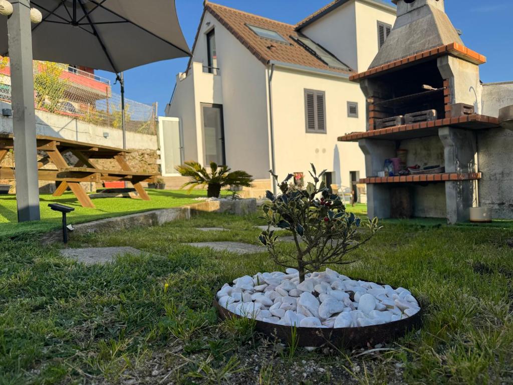 a bowl of rocks in the grass in front of a house at Casa Cuartel in Redondela