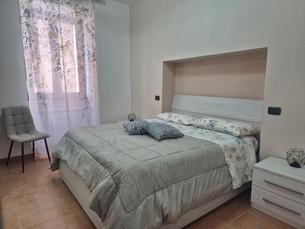 a bedroom with a bed and a chair and a window at Dimora del Funaro con parcheggio in Orvieto