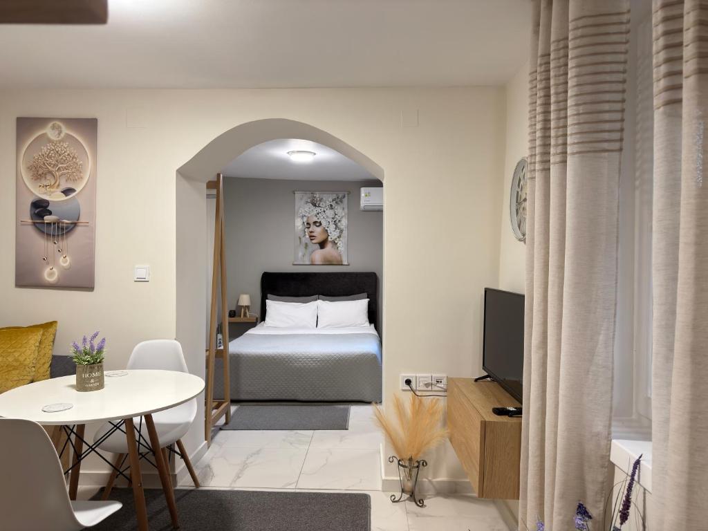 a bedroom with a bed and a table and a tv at The Central Retreat 2 in Mytilene