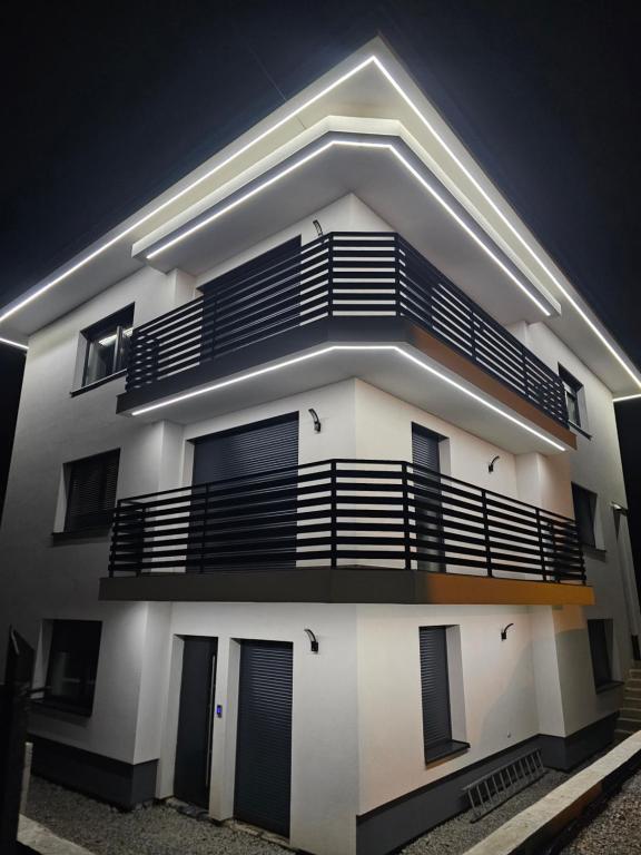 a white apartment building with a balcony at night at Noclegi APART Gorlice in Gorlice