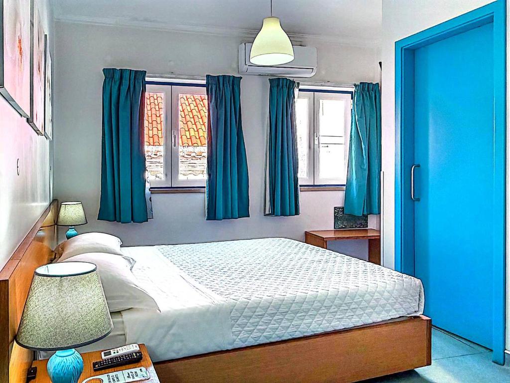 a bedroom with a bed with blue curtains at WEAA Hotel in Nazaré