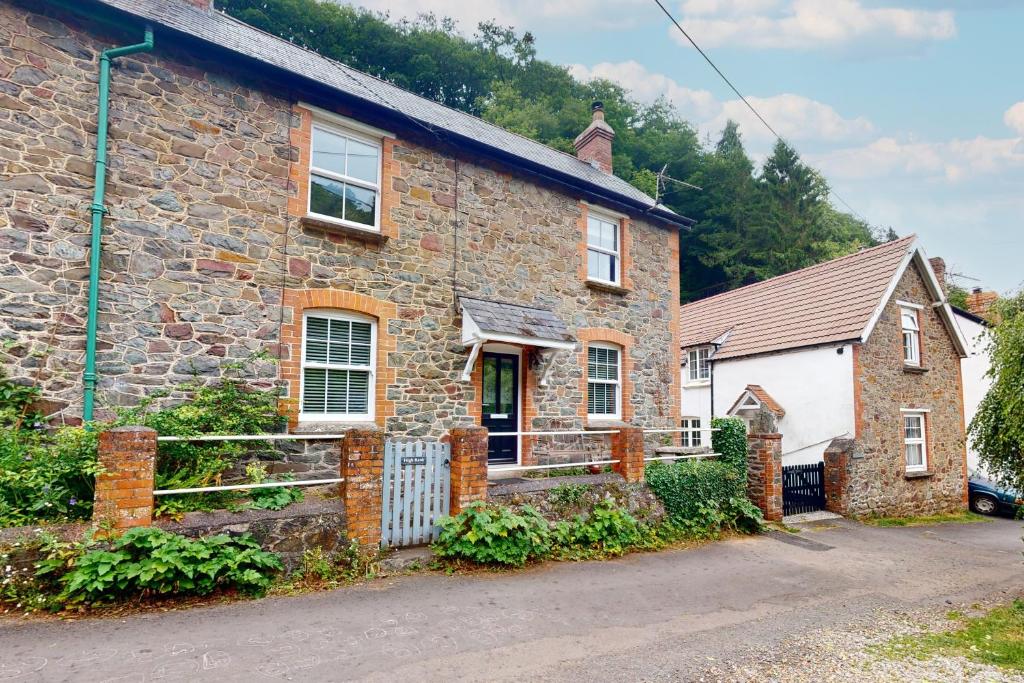 a stone house with a gate in front of it at High Bank Porlock in Porlock