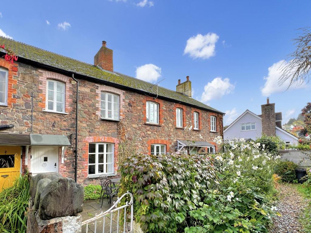 a brick house with a garden in front of it at Grace Cottage Porlock in Porlock