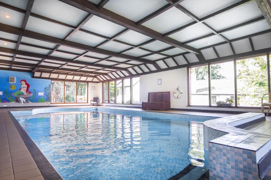 a large swimming pool with a large ceiling at The Smithy nr Huntsham in Tiverton