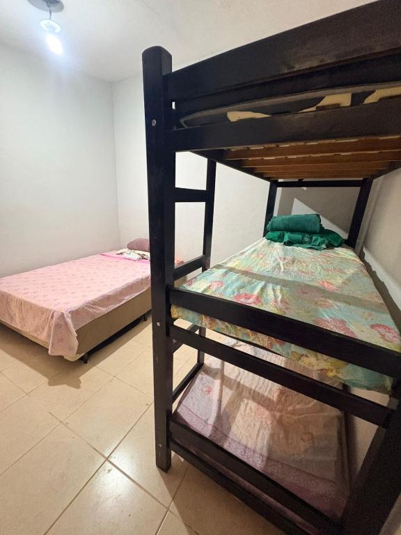 two bunk beds in a room with a bed at Casa de fundo aconchegante 4 solteiros ou 5 se 2 pessoas na casal in Campinas