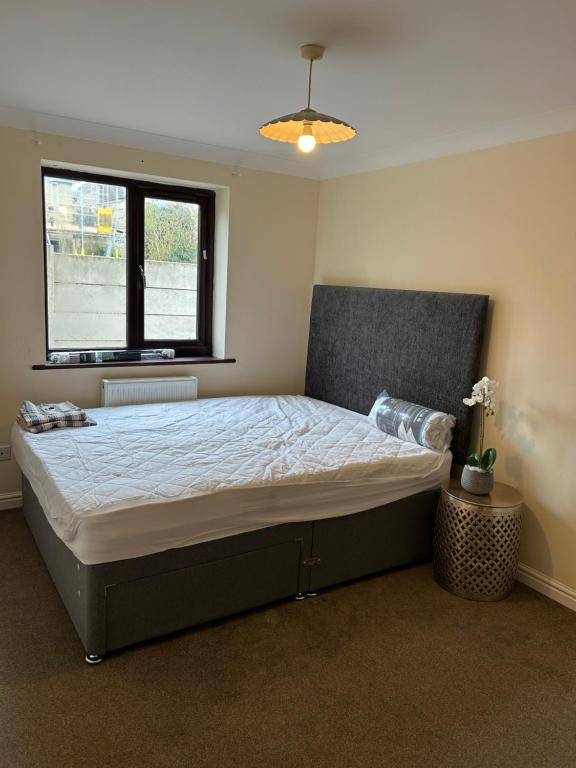 a bedroom with a large bed with a window at Stylish 2-Bed Apartment with Parking in CBG