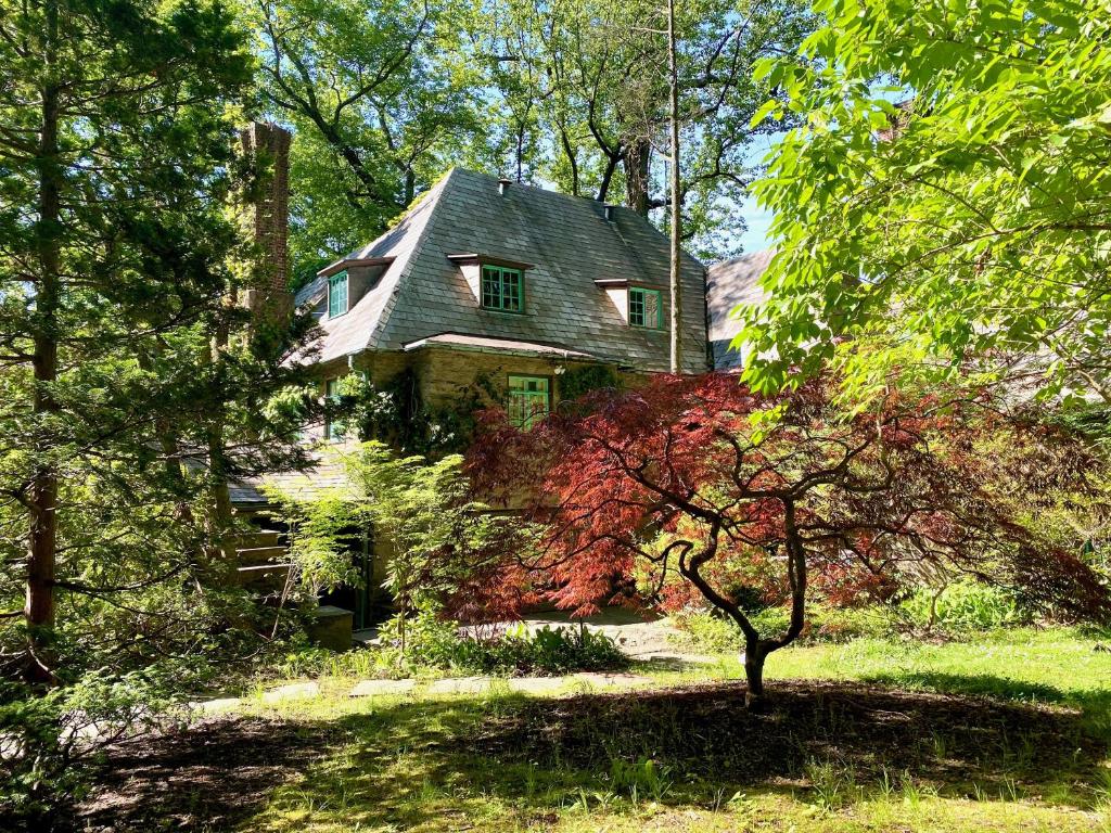 an old house is seen through the trees at 2 Born Wealthy in 1926 in Elkins Park