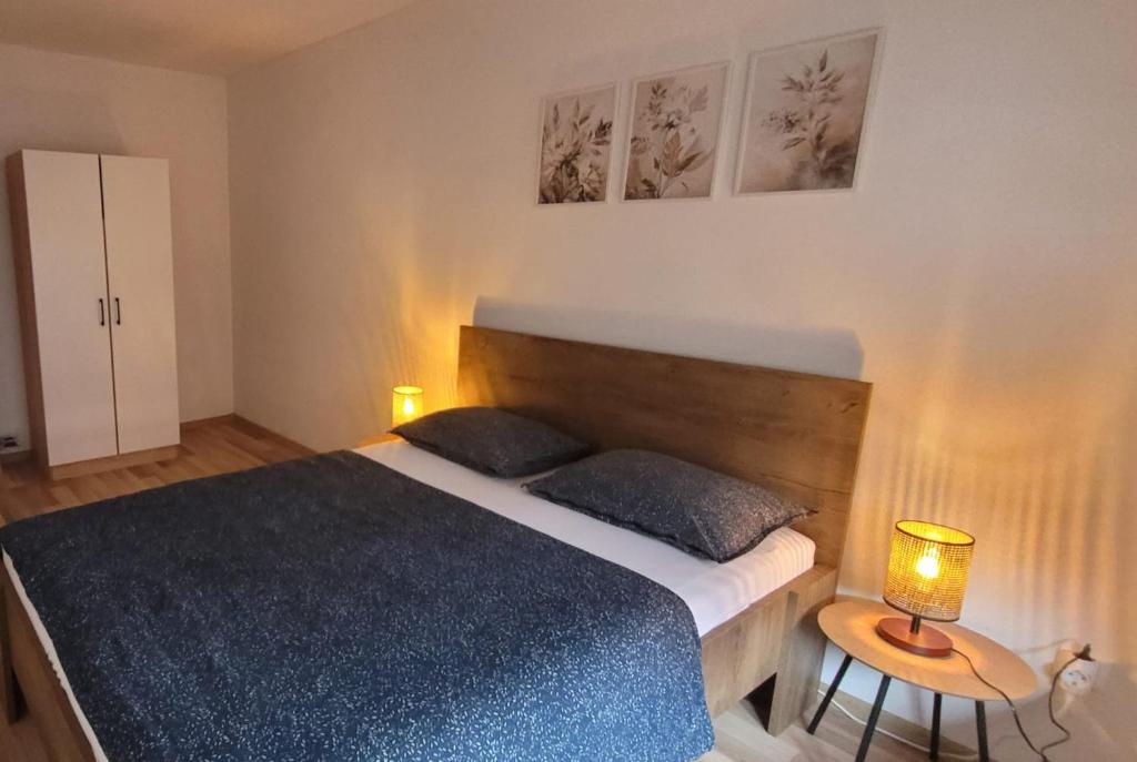 a bedroom with a bed and a table with a lamp at Rose 2 Apartment in Jajce