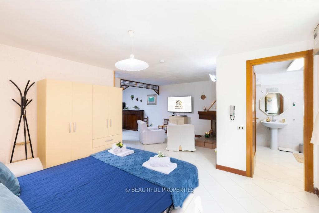 a room with a blue bed and a living room at Room with kitchen & free parking 100 m from the sea in Quartu Sant'Elena