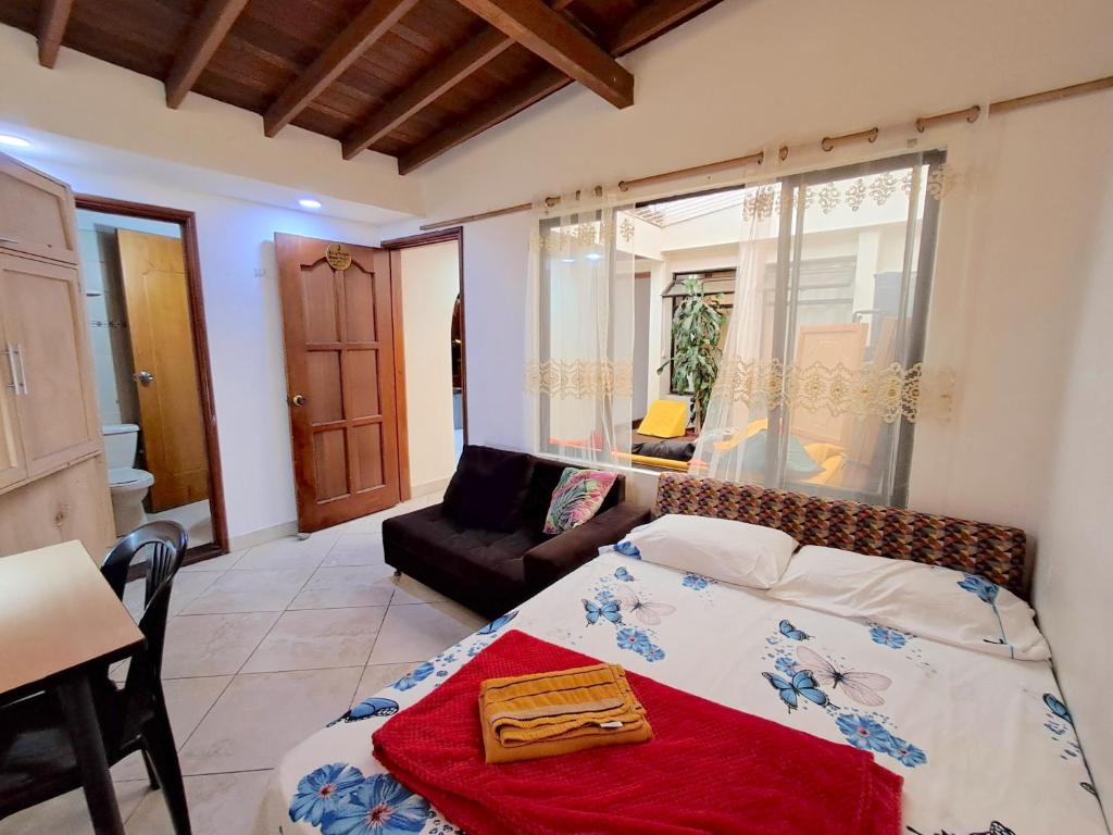 a bedroom with a bed and a couch in a room at Hostal SAVEVA in Medellín