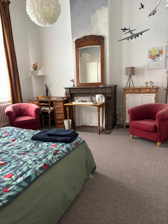 a bedroom with a bed and a desk and a mirror at Maison Dentelle in Caudry