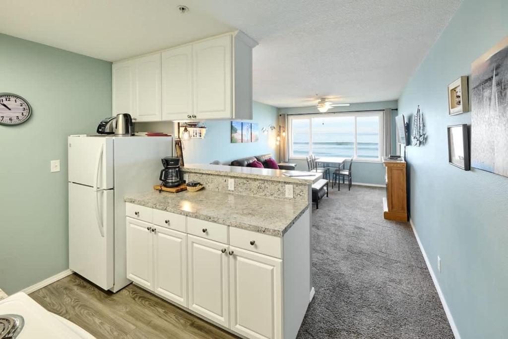 a kitchen with a refrigerator and a living room at Sea Gypsy Rentals in Lincoln City