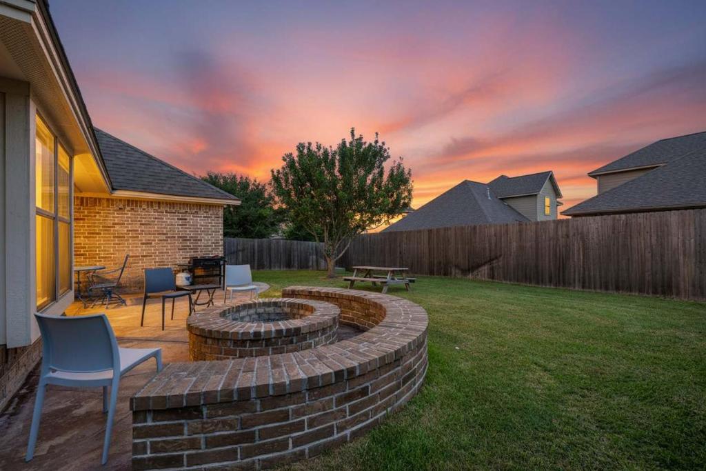 a backyard with a fire pit in the yard at 8min Texas A&M 1 King Beds firepit GriddleGrill in College Station