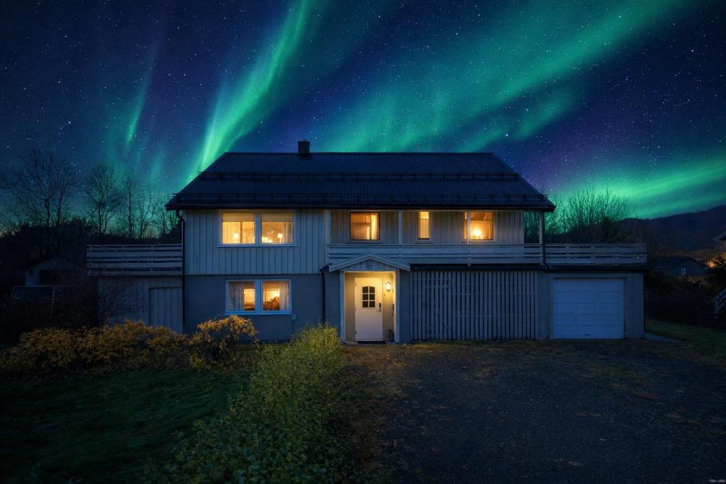 a house with the northern lights in the sky at Alam,s Villa in Kabelvåg
