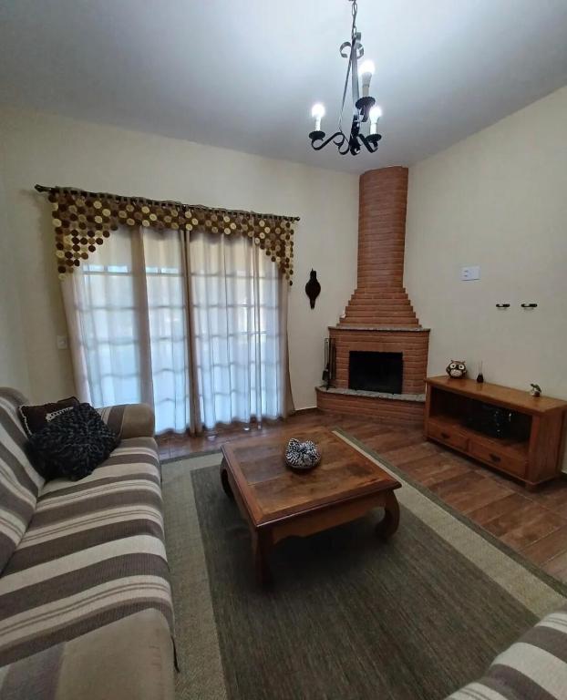 a living room with a couch and a fireplace at Chacara pais e filhas in Socorro