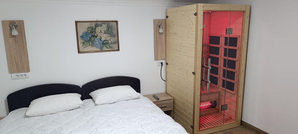 a bedroom with a bed and a glass door at Petrovaradinski Dvor in Petrovaradin