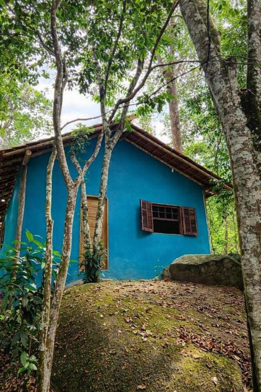 a blue house in the middle of the forest at Casa na Mata - 2 min da Praia de fora com WiFi in Paraty