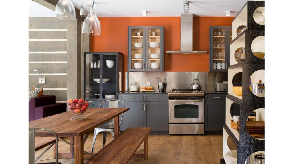 a kitchen with orange walls and a wooden table at Bavarian Chalet 1 in Taos Ski Valley