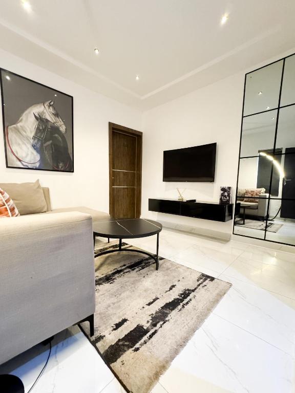 a living room with a couch and a tv at Luxe Apartments Surulere in Lagos
