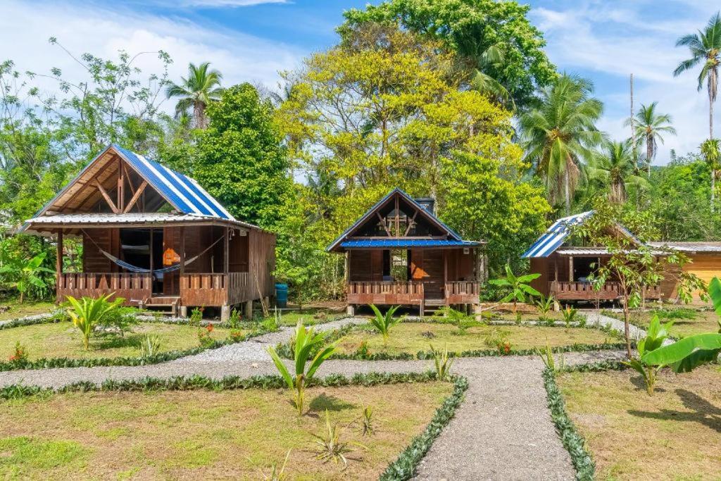 a resort with two cottages in a garden at Ecolodge Azul Paradise in Nuquí